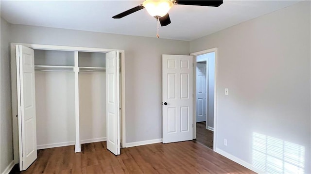 unfurnished bedroom featuring ceiling fan, a closet, baseboards, and wood finished floors