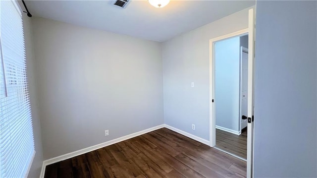 unfurnished bedroom with visible vents, dark wood-type flooring, and baseboards