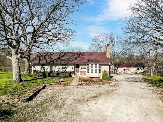 28314 S Bennett Rd, Freeman, MO 64746 - view of front of house featuring dirt driveway, a chimney, and metal roof