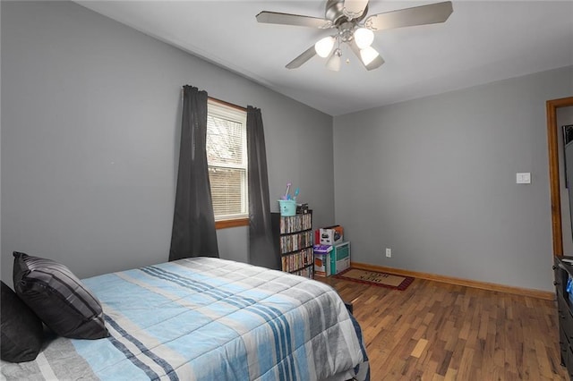 bedroom featuring ceiling fan, baseboards, and wood finished floors