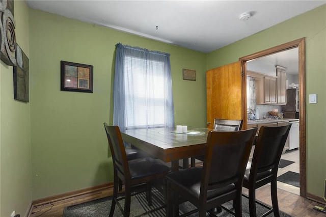 dining space with wood finished floors and baseboards