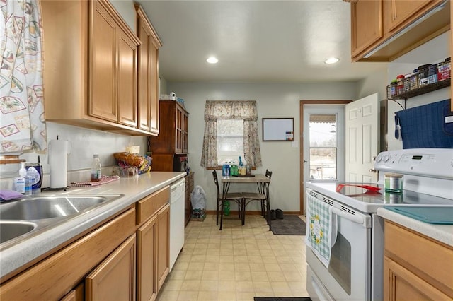 kitchen with a sink, recessed lighting, white appliances, light countertops, and baseboards