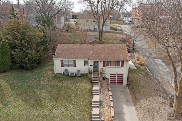 single story home featuring a shingled roof, concrete driveway, a garage, and a front yard