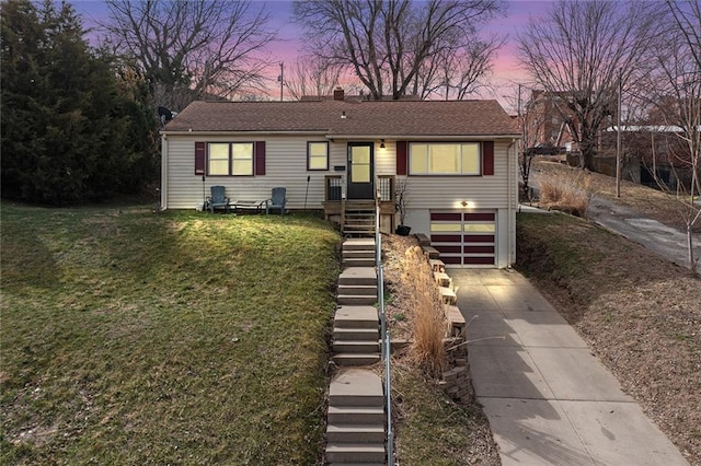 view of front of house featuring a yard, stairway, concrete driveway, and a garage