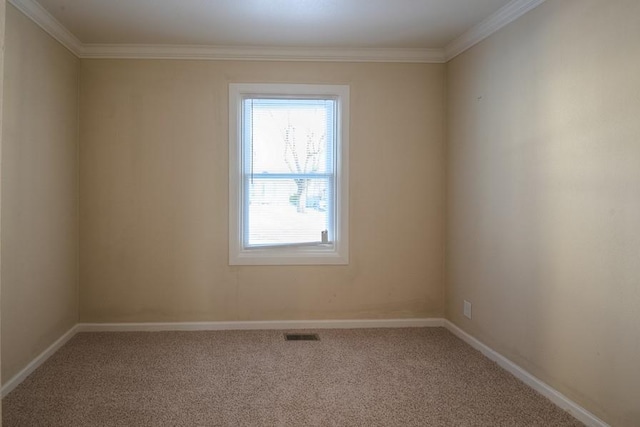 empty room featuring visible vents, baseboards, carpet floors, and ornamental molding