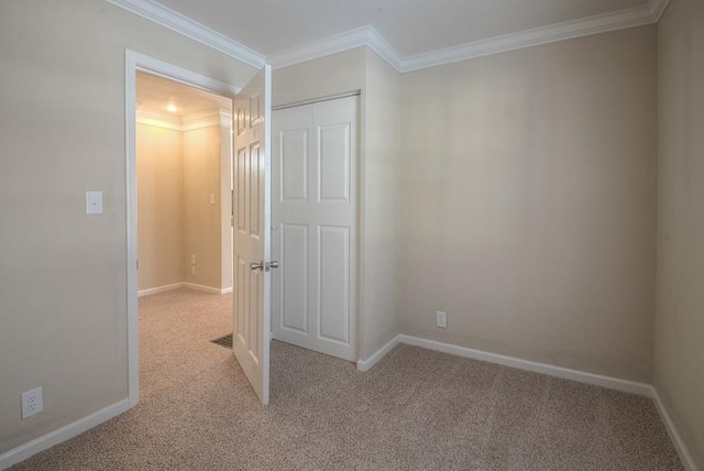 unfurnished bedroom with baseboards, carpet floors, a closet, and ornamental molding