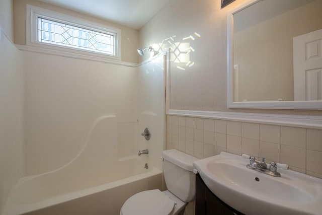 bathroom featuring bathing tub / shower combination, toilet, tile walls, and vanity