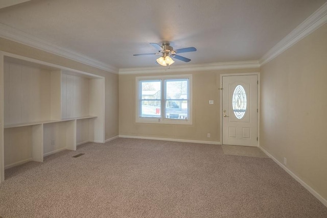 entryway featuring ceiling fan, baseboards, light carpet, and ornamental molding