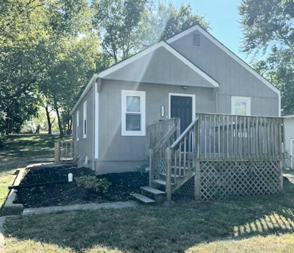 back of house with a deck and a yard