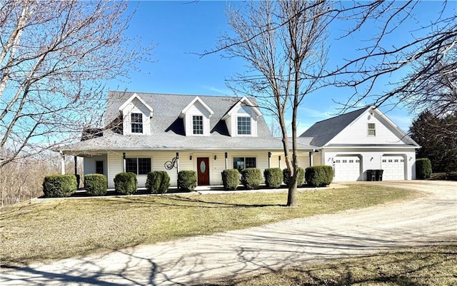cape cod home featuring a garage, a front lawn, and driveway