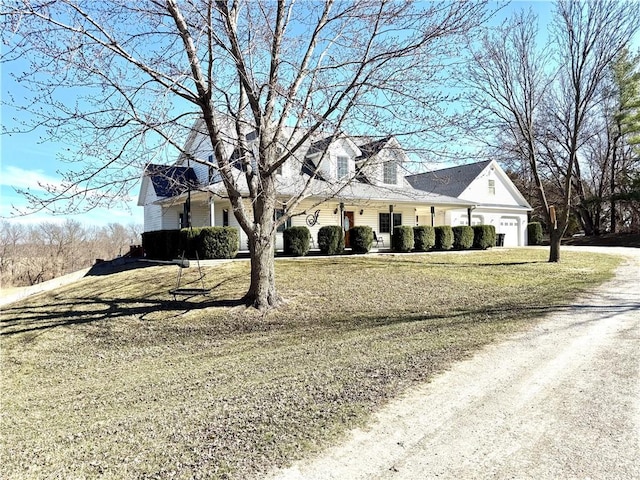 cape cod home featuring driveway, a front lawn, and a garage