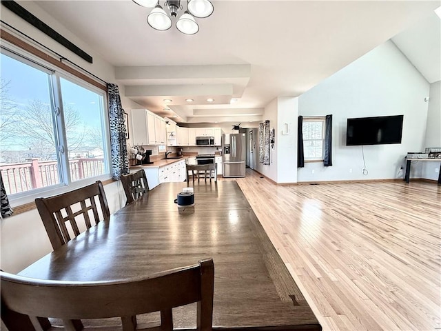 dining space with a notable chandelier, light wood-style flooring, and baseboards