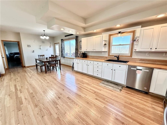 kitchen featuring open shelves, butcher block countertops, a sink, light wood-style floors, and stainless steel dishwasher