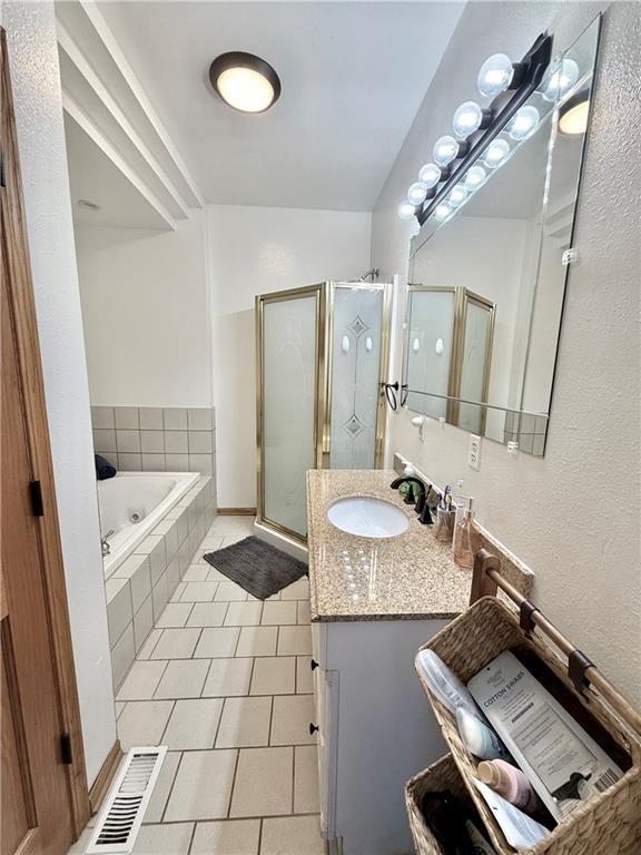 full bath featuring visible vents, a garden tub, a stall shower, tile patterned flooring, and vanity