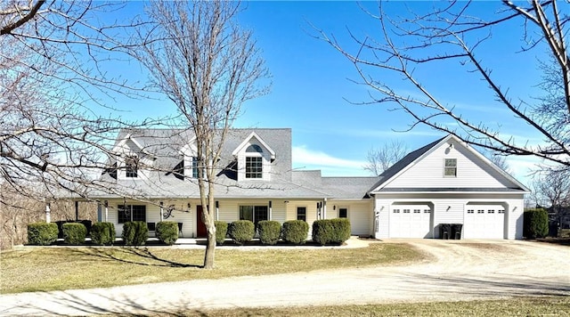 cape cod home with a front yard, an attached garage, and driveway