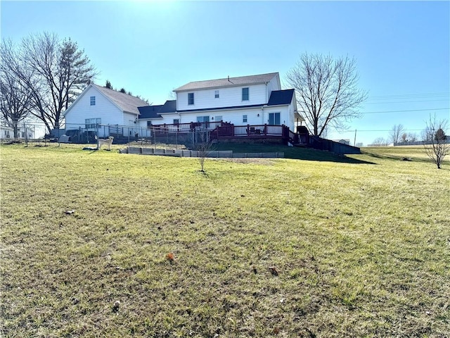 rear view of house featuring a yard, a deck, and fence