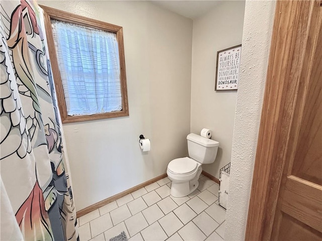 full bath featuring tile patterned floors, toilet, a shower with shower curtain, and baseboards