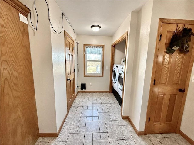 washroom featuring washer and clothes dryer, laundry area, stone finish flooring, and baseboards