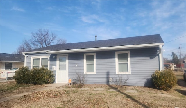 back of property featuring roof with shingles