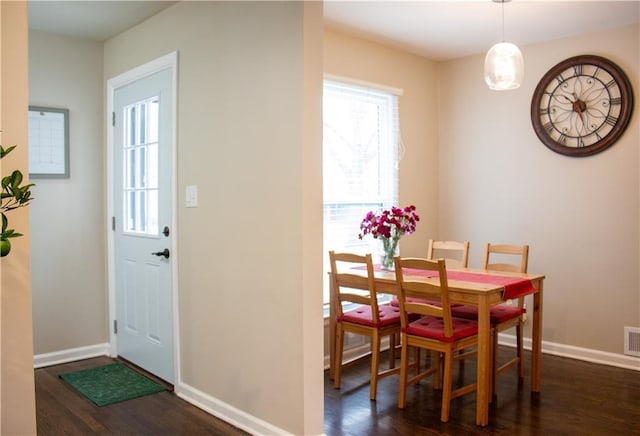 dining space with dark wood-type flooring, visible vents, and baseboards