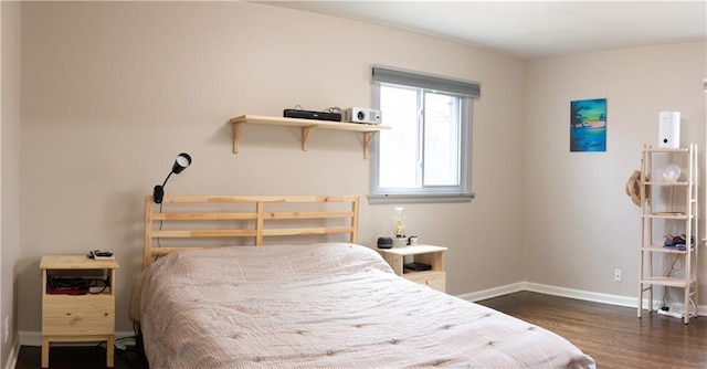 bedroom with baseboards and wood finished floors