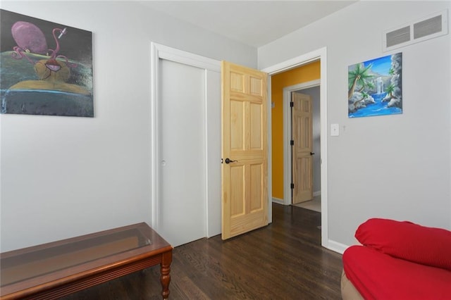 living area featuring visible vents, baseboards, and dark wood-type flooring