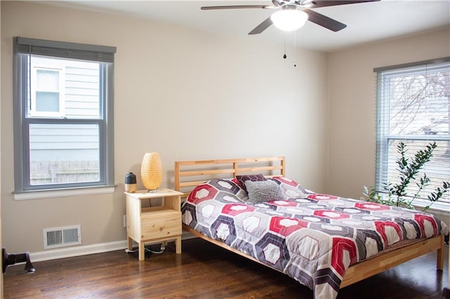 bedroom featuring visible vents, ceiling fan, baseboards, and wood finished floors