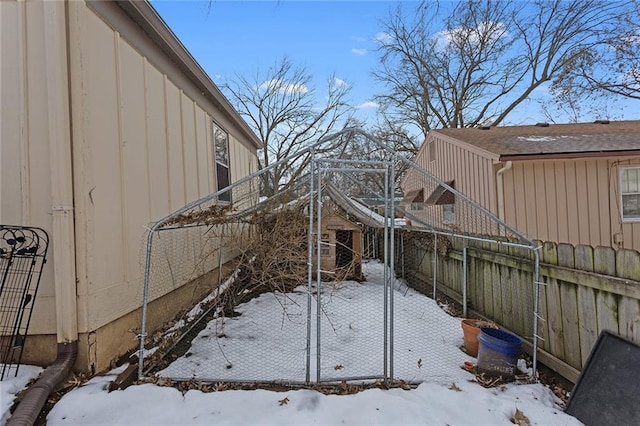 snowy yard featuring fence