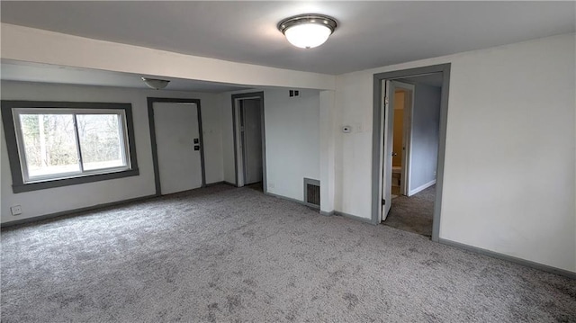 unfurnished room with visible vents, baseboards, and carpet flooring