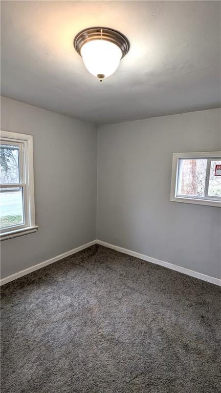 carpeted spare room with a healthy amount of sunlight and baseboards