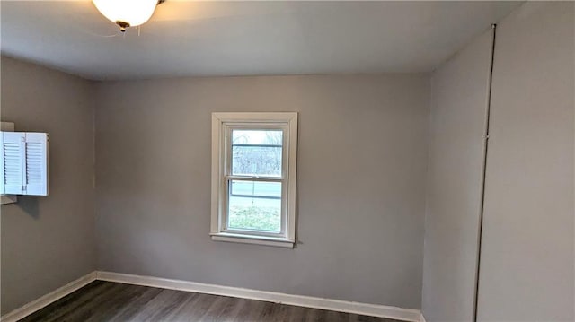 spare room with dark wood-style floors and baseboards