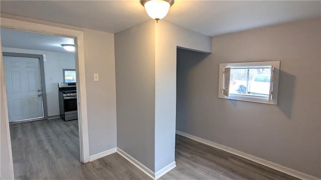 hallway featuring baseboards and wood finished floors