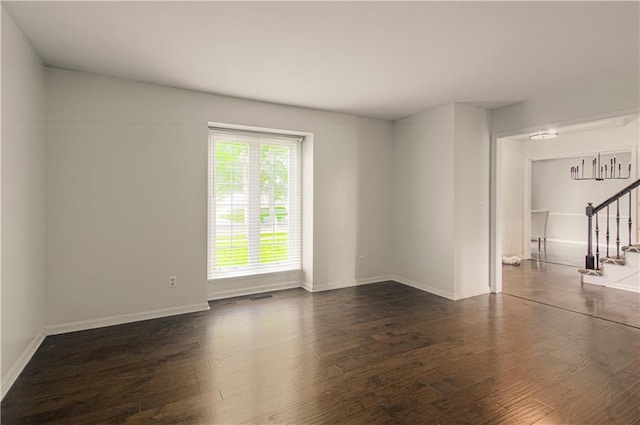 11643 Glen Arbor Ter, Kansas City, MO 64114 - empty room with stairway, dark wood-type flooring, and baseboards