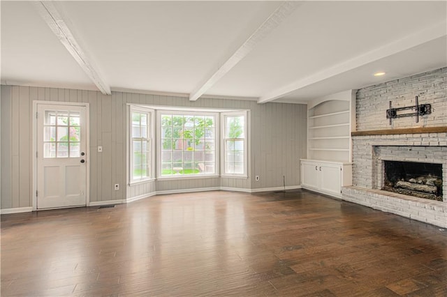 11643 Glen Arbor Ter, Kansas City, MO 64114 - unfurnished living room with beamed ceiling, dark wood-type flooring, a fireplace, and baseboards