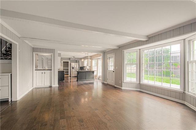 11643 Glen Arbor Ter, Kansas City, MO 64114 - unfurnished living room featuring dark wood-style flooring, ornamental molding, beamed ceiling, baseboards, and a decorative wall