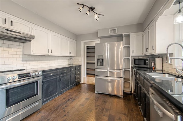 11643 Glen Arbor Ter, Kansas City, MO 64114 - kitchen featuring stainless steel appliances, under cabinet range hood, white cabinetry, and tasteful backsplash
