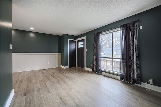 interior space featuring plenty of natural light, wood finished floors, and visible vents