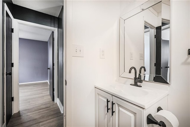 bathroom with vanity, baseboards, and wood finished floors