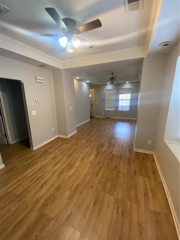 unfurnished living room with baseboards, wood finished floors, visible vents, and ceiling fan