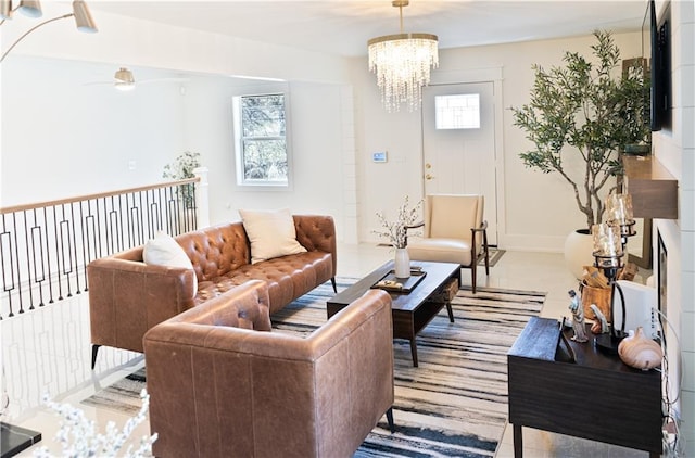 living room with ceiling fan with notable chandelier and baseboards
