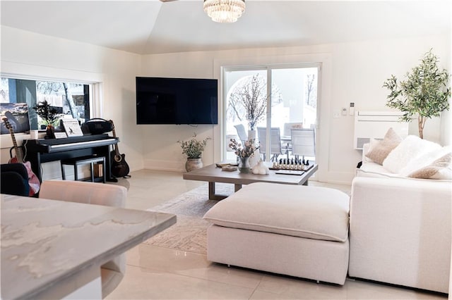 living room with light tile patterned flooring, a notable chandelier, baseboards, and lofted ceiling