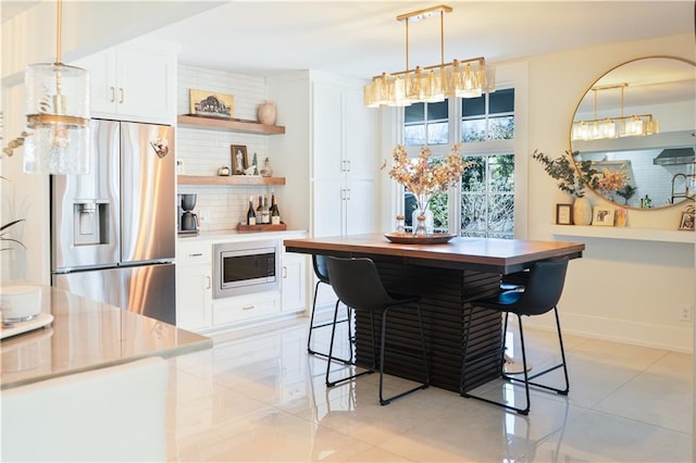kitchen featuring baseboards, open shelves, stainless steel appliances, white cabinetry, and tasteful backsplash