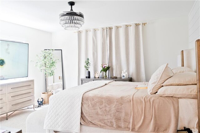 carpeted bedroom with a notable chandelier