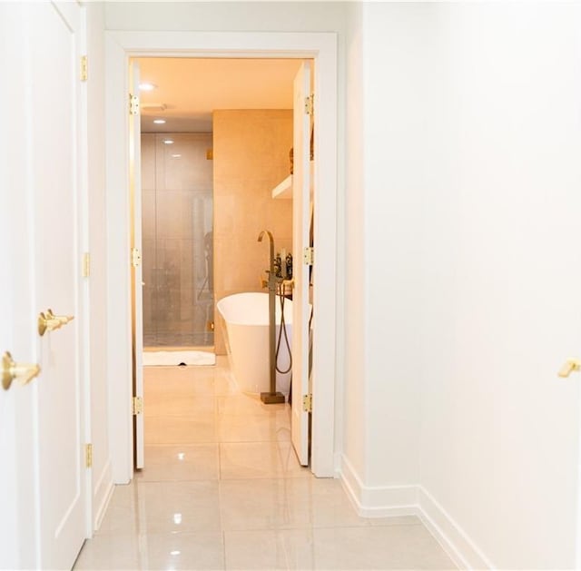 hallway with light tile patterned floors and baseboards