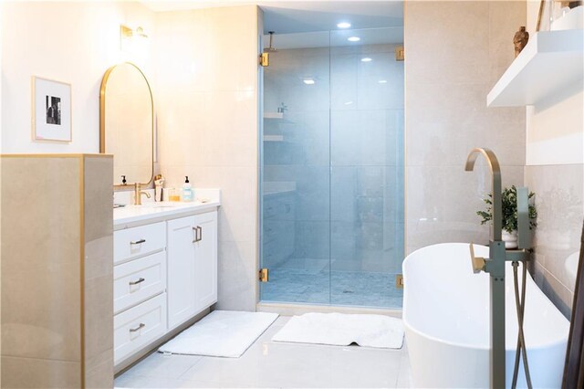 full bath featuring a soaking tub, tile walls, a stall shower, and vanity