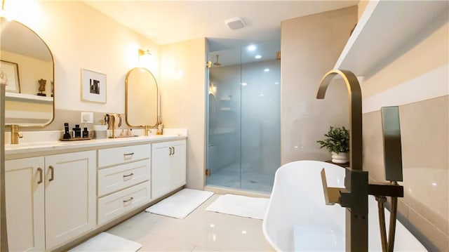 bathroom with a freestanding tub, a sink, a shower stall, tile patterned flooring, and double vanity
