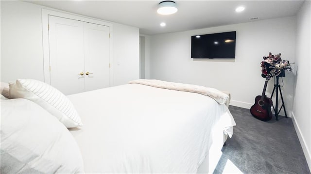 bedroom featuring a closet, recessed lighting, baseboards, and dark colored carpet