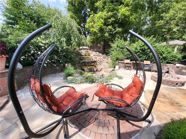view of patio / terrace featuring a fire pit and fence