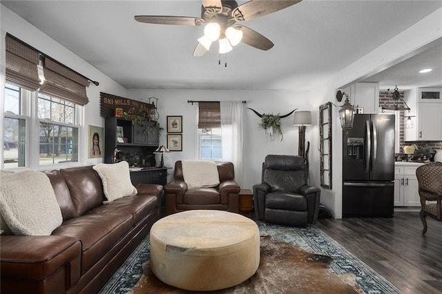 living room featuring dark wood finished floors, a healthy amount of sunlight, and ceiling fan