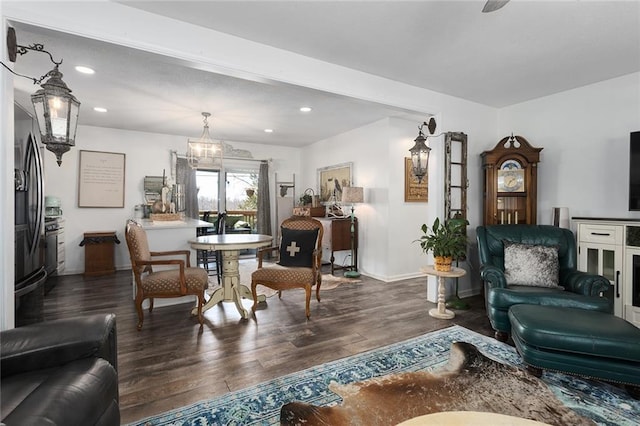 living area featuring a notable chandelier, recessed lighting, baseboards, and wood finished floors